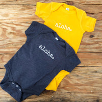 gold yellow and navy blue gender neutral baby Ivy & Co. onesie with white writing that says aloha